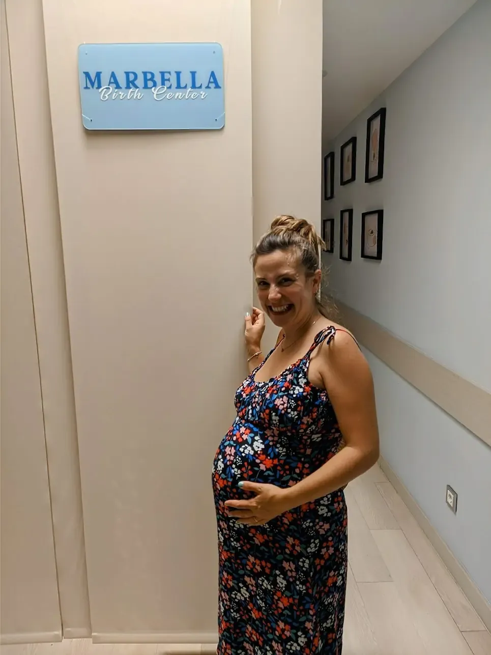 Tania Casamitjana, embarazada de su segunda hija, sonríe junto al cartel del Marbella Birth Center